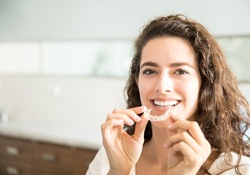 woman at dental office holding Invisalign in Bartlesville