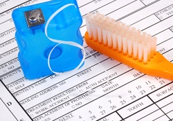 Dental insurance claim form, floss, and toothbrush