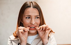 Patient putting on clear aligner in treatment room