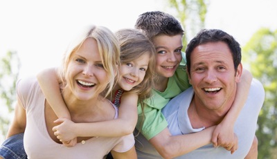 Smiling mother father and two children outdoors