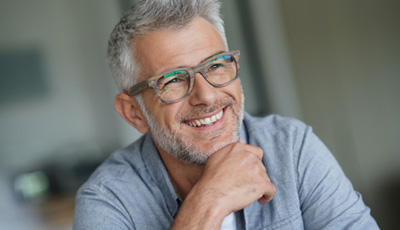 A smiling middle-aged man with trendy eyeglasses