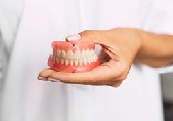 Someone holding a set of dentures