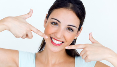 Woman pointing to her beautiful smile