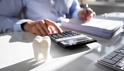 man calculating the cost of a dental emergency appointment