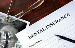 Dental insurance paperwork on wooden desk 