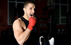 Boxer placing mouthguard in his mouth