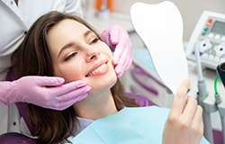 A woman admiring the results of her cosmetic dental work