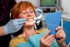 A woman smiling at the dentist.