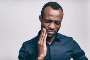 person with a toothache holding their mouth