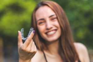 a woman smiling with her clear Invisalign aligners