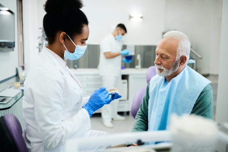 A dentist explaining denture wait time to a patient