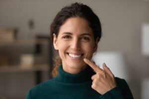 Woman pointing to her straight white smile